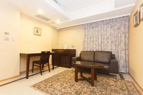 a living room with a couch and a table at SLV Hotel Group-SLV Business Hotel in Zhonghe