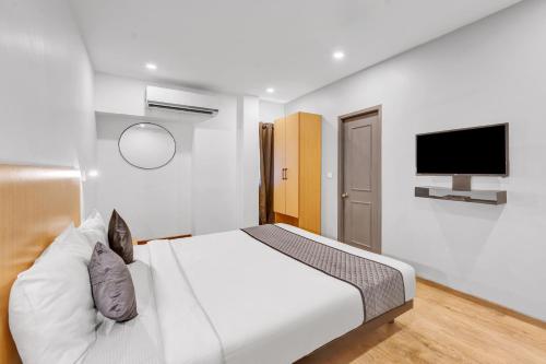 a bedroom with a bed and a flat screen tv at Upar Hotels Uthandi, ECR in Chennai