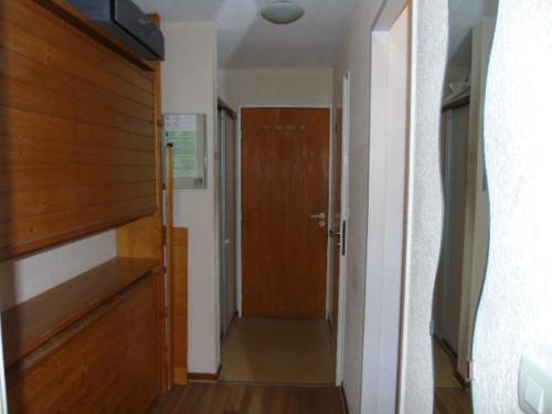 um corredor com uma porta de madeira num quarto em Studio Valfréjus, 1 pièce, 3 personnes - FR-1-561-52 em Valfréjus