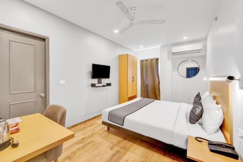 Habitación de hotel con cama y escritorio en Upar Hotels Uthandi, ECR en Chennai