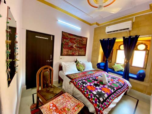Hotel Murad Haveli Jaisalmer في جيلسامر: غرفة نوم مع سرير ولحاف ملون عليها