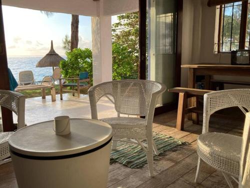 stolik i krzesła w pokoju z widokiem na ocean w obiekcie BlueMoon Studio on the Beach! w mieście Trou dʼ Eau Douce