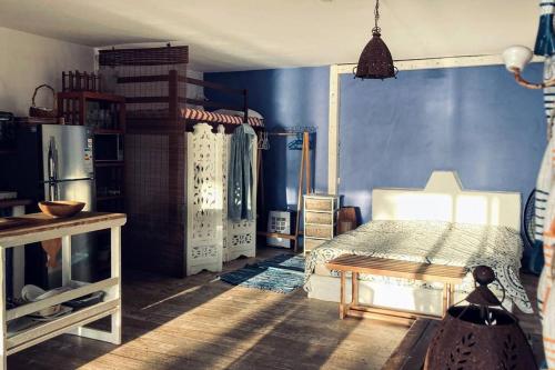 a bedroom with a bed and a blue wall at BlueMoon Studio on the Beach! in Trou dʼ Eau Douce
