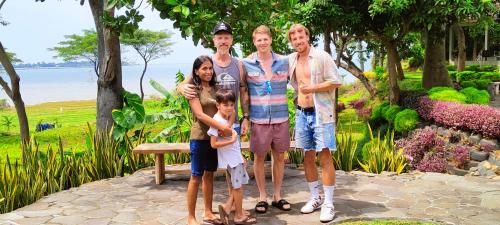 a family posing for a picture in a park at La Collina Villa in Jepara