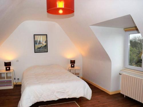 une chambre avec un lit blanc et une fenêtre dans l'établissement Maison bretonne avec cour fleurie, WIFI et vélos à 1,4 km des plages à Trébeurden - FR-1-368-71, à Trébeurden