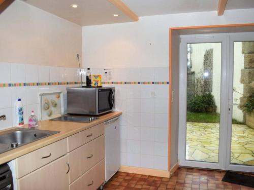 uma cozinha com um lavatório e um micro-ondas em Maison Trébeurden, 3 pièces, 5 personnes - FR-1-368-71 em Trébeurden
