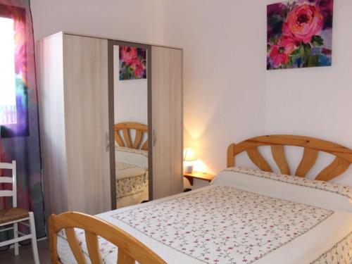 une chambre avec un lit et un miroir dans l'établissement Appartement avec Terrasse, 6 Couchages, à 2 Pas de la Plage - Gruissan - FR-1-229-777, à Gruissan