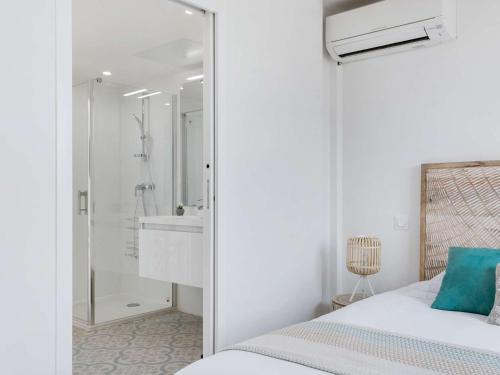 - une chambre blanche avec une douche et un lit dans l'établissement Appartement lumineux 3 pièces - Neuf 2021 - Climatisé - Grande terrasse - Parking - WIFI inclus - FR-1-326-730, à Marseillan