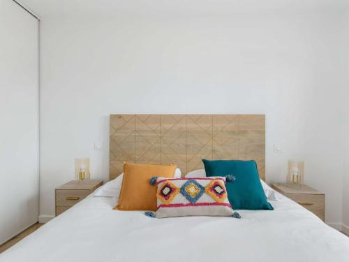 - un lit blanc avec 4 oreillers dans l'établissement Appartement lumineux 3 pièces - Neuf 2021 - Climatisé - Grande terrasse - Parking - WIFI inclus - FR-1-326-730, à Marseillan