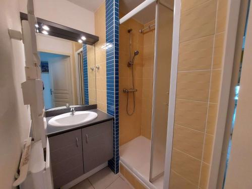 une salle de bain avec un lavabo et une douche dans l'établissement Appartement climatisé 2P cabine, 50m de la plage, parking, loggia, équipements modernes - FR-1-326-747, à Marseillan