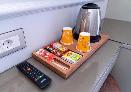 a table with a coffee maker and two mugs and a remote control at Cetin Port Hotel in Istanbul
