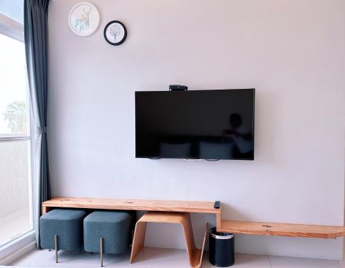 a living room with a tv on a white wall at Happy Fat B&B 寵物友善 in Taitung City