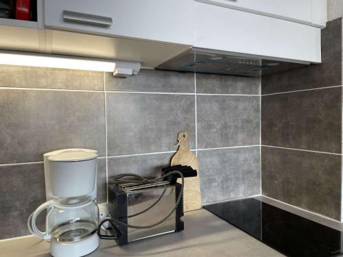 a kitchen counter with a coffee maker on a counter top at Appartement Montgenèvre, 1 pièce, 2 personnes - FR-1-330D-84 in Montgenèvre