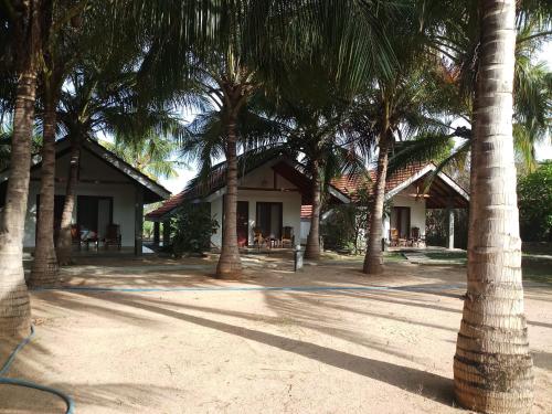 a group of palm trees in front of a building at Villa Nilaveli Cabana in Nilaveli