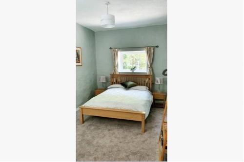 um quarto com uma cama e uma janela em The Annexe em Radstock