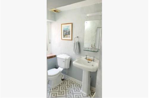 uma casa de banho com um WC branco e um lavatório. em The Annexe em Radstock