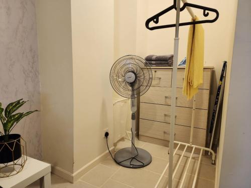 a room with a fan in the corner of a room at Avenpeak Homestay Tamarind Wifi, Netflix, Iron, Filter, TV, Self Checkin in Cyberjaya
