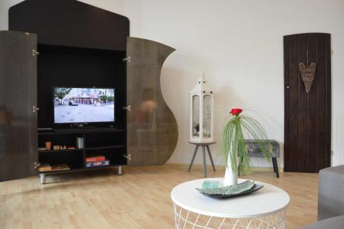 a living room with a tv and a table at Ferienwohnung Leuchtturm 29a in Guben