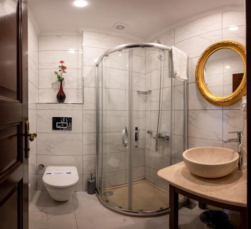 La salle de bains est pourvue d'une douche, de toilettes et d'un lavabo. dans l'établissement Osmanhan Hotel, à Istanbul