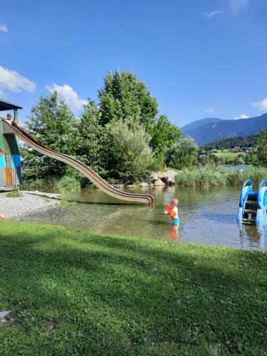 a child in the water with a slide at Rauterhof in Hermagor