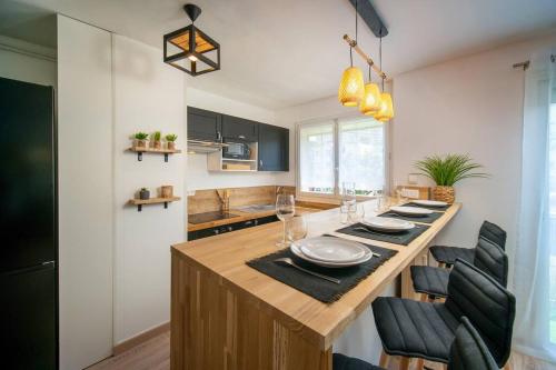une cuisine avec une grande table en bois et des chaises noires dans l'établissement Fully equipped apartment with parking 6 beds, à Marseille
