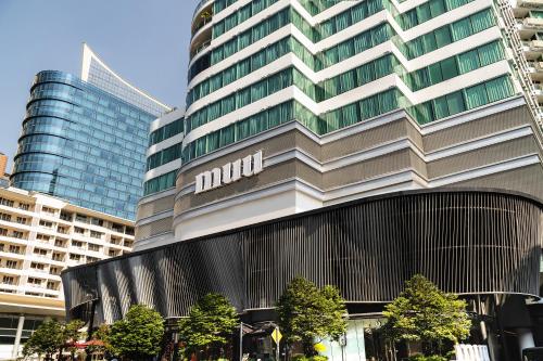 un grand bâtiment avec un panneau sur son côté dans l'établissement MUU Bangkok Hotel, à Bangkok