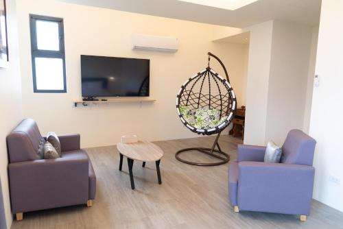 a living room with two chairs and a flat screen tv at 三仙台日出民宿 in Chenggong
