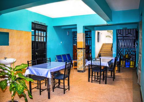 a restaurant with blue walls and tables and chairs at Dahlia Hotel and Accommodation in Homa Bay