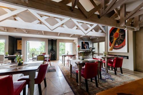 a dining room with tables and red chairs at Migdash Guesthouse in Hartbeespoort