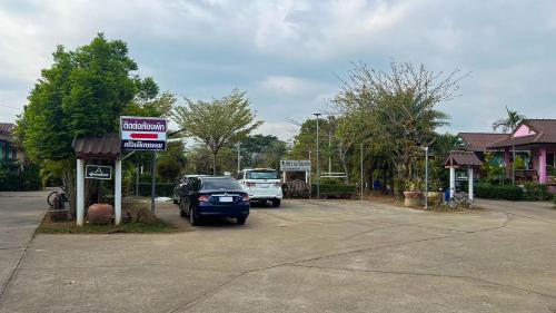 a car parked in a parking lot next to a truck at Chatchawan Resort in Ban Tha Sao