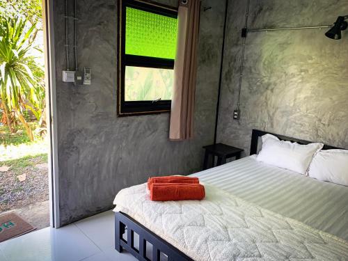 a bedroom with a large bed with a window and a window at Ozone Beach House in Ko Lanta