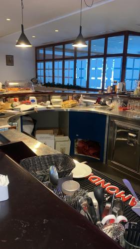a large kitchen with a counter with dishes and utensils at Ploner villaggio Turistico in Dobbiaco