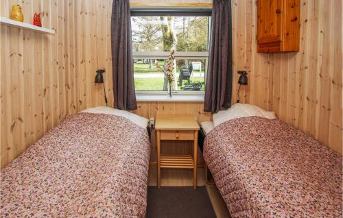 2 bedden in een kamer met een bureau en een raam bij 3 Bedroom Stunning Home In Sams in Onsbjerg