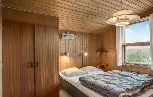 1 dormitorio con 1 cama en una pared de madera en Pet Friendly Home In Hadsund With Wifi en Haslevgårde