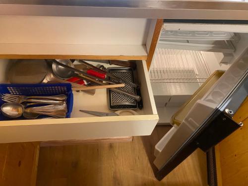 an open drawer with utensils in a cabinet at Ploner villaggio Turistico in Dobbiaco