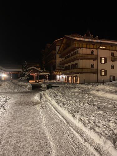 a building in the snow at night at Ploner villaggio Turistico in Dobbiaco