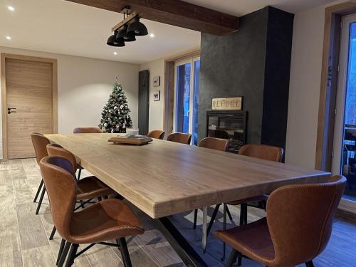 a dining room with a large wooden table and a christmas tree at LE REFUGE LES 2 ALPES 1800 in Les Deux Alpes