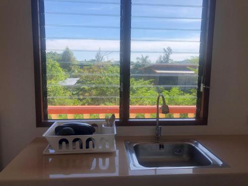 encimera de cocina con fregadero y ventana en Phumin Apartment en Ko Lanta