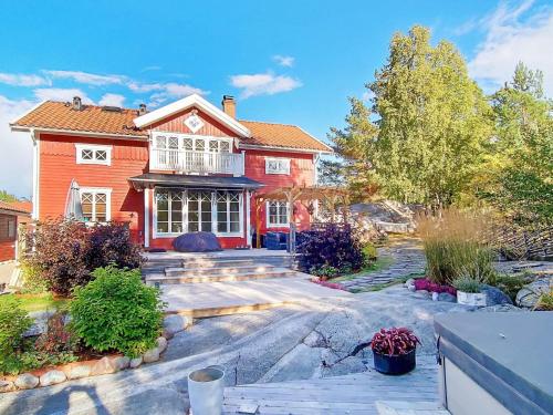 uma grande casa vermelha com uma entrada em 8 person holiday home in VAXHOLM em Rindö