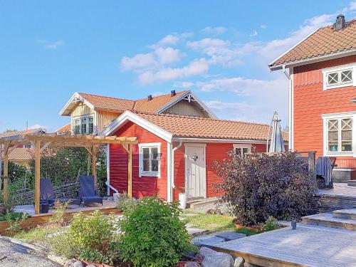 una casa roja con un banco delante en 8 person holiday home in VAXHOLM en Rindö