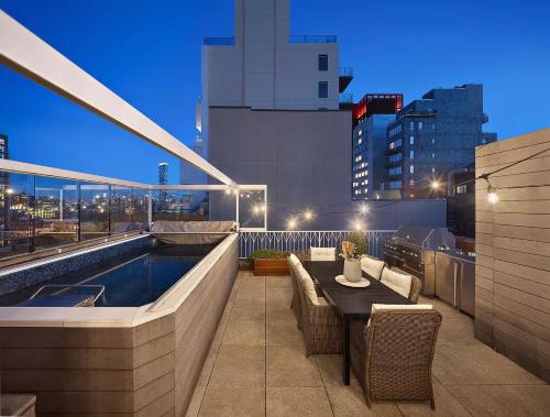 a rooftop patio with a pool and a table and chairs at Sweet Serenity in New York
