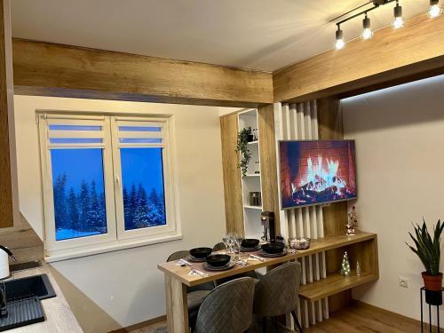 a dining room with a table and a window at Pinewood apartment Jahorina in Jahorina