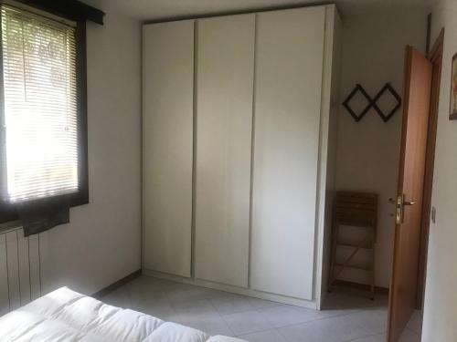 1 dormitorio con 1 cama y armario grande en Ruscello apartment, en Abetone