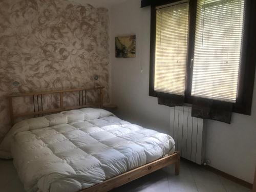 1 dormitorio con 1 cama en una habitación con ventanas en Ruscello apartment, en Abetone