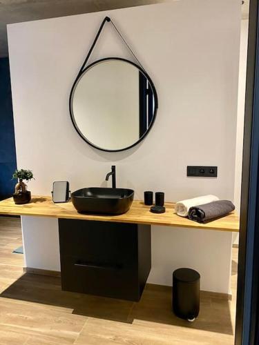 a bathroom with a sink and a mirror on a counter at Le Moulin de la Piérie in Neufchâteau