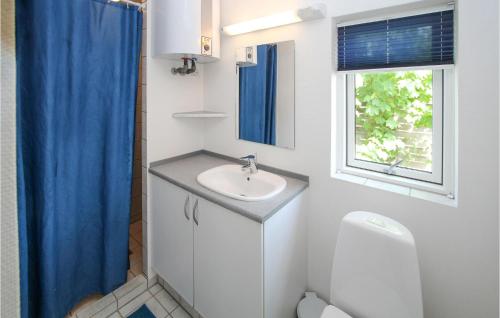 uma casa de banho com um lavatório, um WC e uma janela. em 2 Bedroom Lovely Home In Sams em Onsbjerg