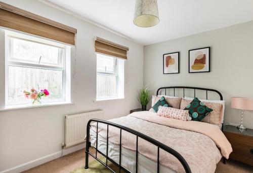 a bedroom with a bed and two windows at White House in Bournemouth