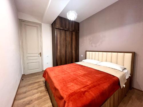 - une chambre avec un grand lit et une couverture rouge dans l'établissement leselidze apartament, à Tbilissi