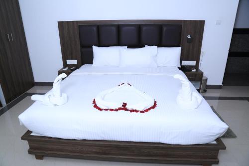 a bedroom with a white bed with a red necklace on it at CHRISTIAN GUEST HOUSE in Vellore