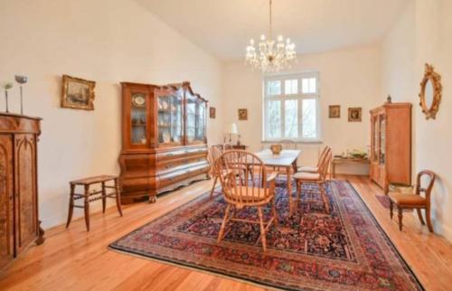 une salle à manger avec une table, des chaises et un lustre dans l'établissement Weiße Villa 1, à Duderstadt